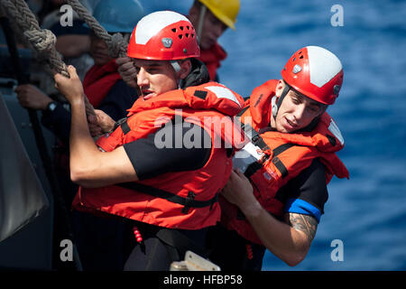 Pazifik (29. September 2012) Operations Specialist 3. Klasse Ryan Comtois, ein Such- und Rettungs-Schwimmer an Bord der Ticonderoga-Klasse geführte Flugkörper Kreuzer USS Cowpens (CG 63), kommuniziert mit Segler, wie sie ein Festrumpf Schlauchboot vom Bootsdeck Port Seite senken. Cowpens ist Teil des George Washington Carrier Strike Group, der U.S. Navy nur vorwärts Carrier Strike Group mit Sitz aus Yokosuka, Japan im Einsatz und führt derzeit eine Routine Westpazifik Patrouille. (Foto: U.S. Navy Mass Communication Specialist 3. Klasse Paul Kelly / veröffentlicht) 120929-N-TX154-122 Join die Stockfoto