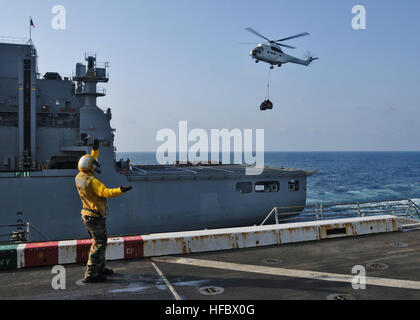 Arabisches Meer (17. Oktober 2012) Luftfahrt Boatswain Mate (Handling) 2. Klasse Kaitlin Shotwell leitet ein AS 332 Super Puma Helikopter liefern Fracht vom Nilitary Sealift Command trockene Ladung und Munition Schiff USNS Washington Kammern (T-AKE-11) zu den amphibious Transport dock Schiff USS New York (LPD-21). New York ist Teil der Iwo Jima amphibisches bereit Gruppe mit eingeschifften 24. Marine Expeditionary Unit und zur Unterstützung der Sicherheit im Seeverkehr Operationen und Sicherheitsbemühungen Zusammenarbeit Theater in den USA bereitgestellt wird 5. Flotte Aufgabengebiet. Der US-Marine wird ständig auf bereitgestellt. Stockfoto