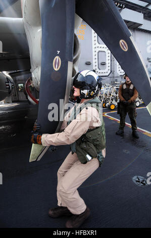 Der Befehlshaber der Carrier Airborne Early Warning Squadron 117 inspiziert die Propeller einer E-2C Hawkeye auf der USS Nimitz während eines Routineflugs als Teil eines Einsatzes in der 5. US-Flotte, in dem regionale Sicherheit und Stabilität im Mittelpunkt stehen. Stockfoto