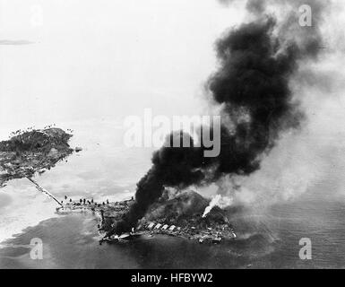 Guadalcanal-Tulagi Landungen, 7. bis 9. August 1942: Feuer brennen unter japanische Einrichtungen und Wasserflugzeuge auf Tanambogo Insel, östlich von Tulagi, am ersten Tag der Invasion, 7. August 1942. Dieser Blick geht über SSW mit Gavutu Insel auf der linken, verbunden mit Tanambogo durch einen Damm.  Offizielle US-Navy, Foto, jetzt in den Sammlungen der National Archives. Gavutu Und Tanambogo Stockfoto