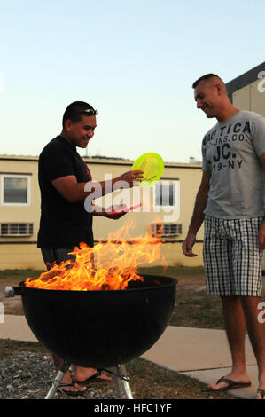 GUANTANAMO BAY auf Kuba – Petty Officer 3rd Class Alex Kaleikini und religiösen Program Specialist 3. Klasse Adam Donato mit Joint Task Force (JTF) Guantanamo, plaudern über Disc-Golf während der Zubereitung von Speisen für der Grill an der Cuzco-Kaserne, 6. April 2010. Kaleikini hat eine Leidenschaft für das Kochen und grills für seine Freunde jede Woche. JTF Guantanamo führt sicher, humane, rechtliche und transparente Pflege und Obhut der Gefangenen, einschließlich der Militärkommission und die verurteilten bestellt von einem Gericht freigegeben. Die JTF führt Intelligenzansammlung, Analyse und Verbreitung für den Schutz von det Stockfoto