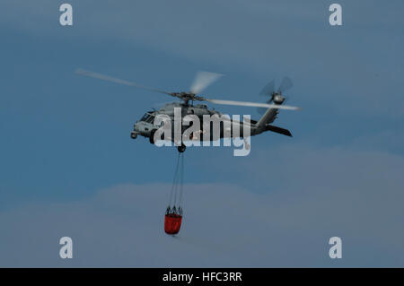 SANTA RITA, Guam (20. Februar 2015) – ein MH-60 s Knighthawk mit "Insel Ritter" der Hubschrauber Meer bekämpfen Squadron (HSC)-25, trägt ein "Bambi Bucket" Wasser für eine Brandbekämpfung Ausbildungsmission als Teil des Wildfire Brandbekämpfung Trainingsmissionen 20 Februar am Naval Magazine, Munition Seestreitkräften, Naval Base Guam (NBG) durchgeführt. (US Navy Foto von Jeff Landis/freigegeben) HSC-25 führt ein Lauffeuer training 150220-N-OG363-007 Stockfoto