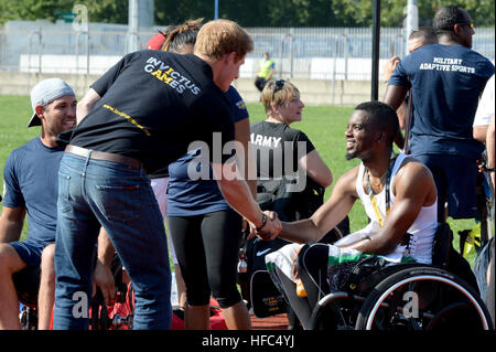 Großbritanniens Prinz Harry grüßt Konkurrenten aus den Vereinigten Staaten während der Beobachtung der letzten Trainings vor dem Start der Invictus Games 2014. Invictus Games ist ein internationaler Wettbewerb, der verwundete, verletzte und kranke Angehörige im Sinne des freundlichen sportlichen Wettkampf zusammenbringt. Amerikanische Soldaten, Matrosen, Piloten und Marines repräsentieren die Vereinigten Staaten im Wettbewerb der in London, England vom 10.-14. September 2014 stattfindet. (Foto: U.S. Navy Mass Communication Specialist 2. Klasse Joshua D. Sheppard/freigegeben) Invictus Games 140908-N-PW494-883 Stockfoto