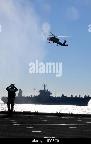 110722-N-WV964-072 CORAL SEA (22. Juli 2011) — A Sailor beobachtet, wie ein MH-60 Sea Hawk vorwärts bereitgestellt amphibische Dock Landungsschiff USS Germantown (LSD-42) und das amphibische Kommando-Schiff USS Blue Ridge (LCC-19 Kreise).  Kommandant, siebte Flotte VADM Scott Van Buskirk, zusammen mit seinen Mitarbeitern, der US-Botschafter in Australien, und anderen US-Militärs und Würdenträger aus Australien, besucht das Schiff um die Einrichtungen zu besichtigen.  Germantown, unter dem Kommando von Commander A. D. Hull, beteiligt Übung Talisman Sabre 2011, eine bilaterale Gefechtsstand und Feld Trainingsübung zur Maint sich Stockfoto