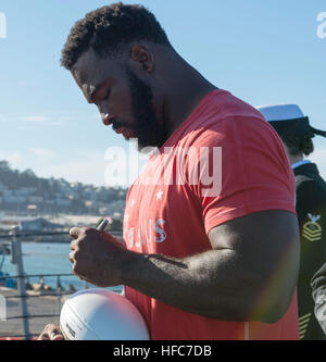 151010-N-KL846-234 SAN FRANCISCO (10. Oktober 2015) Oakland Raider Defensive End, Justin Tuck, Autogramme während einer Tour durch das Schiff während San Francisco Fleet Week 2015 ein Seemann Fußball auf die Fo'c'sle geführte Flugkörper Zerstörer USS Stockdale (DDG-106). San Francisco Fleet Week, jetzt in seinem 35. Jahr feiert das traditionsreiche Marine in der Bay Area, ehrt unsere Nation Soldat innen und erleichtert die jährliche Katastrophe Bereitschaft Weiterbildung zwischen Navy, Marine Corps, Küstenwache und lokalen Ersthelfer. (Foto: U.S. Navy Mass Communication Specialist 2. Klasse Christopher Lindahl / Stockfoto