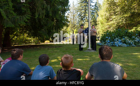 Die Marinestation Everett Color Guard hebt die amerikanische Flagge während einer Farbendemonstration für die Boy Scouts des Mount Baker Council auf und veranschaulicht die zwölffache Fahnenfaltstradition der US Uniformierten Dienste, die den ordentlichen Rücktritt des nationalen Fähnrich symbolisiert. Stockfoto