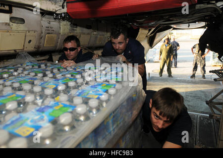 Petty Officer 2. Klasse Donald Boylen, Luftfahrt strukturelle Mechaniker (links), Petty Officer 2. Klasse Justin Leonard, Luftfahrt Elektroniker /-in (Mitte) und Seaman Jamie Salmon, Luft Crewman, schieben Paletten des Wassers in einem Flugzeug c-2 Greyhound Naval Station Guantanamo Bay. Die Paletten des Wassers sollen nach Haiti im Rahmen der Operation Unified Response, humanitäre Hilfe in der Nachmahd von einem Erdbeben der Stärke 7,0 12. Januar 2010 ausgeliefert. Laden Sie Lieferungen in Kuba 244943 Stockfoto