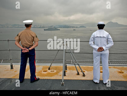 Matrosen und Marinesoldaten, zugeordnet zu künftigen amphibischer Angriff Schiff USS America (LHA-6), stehen in Parade Ruhe während der Besatzung der Schienen, wie das Schiff Rio De Janeiro, Brasilien fährt nach ein viertägigen Hafen besuchen. Amerika reist derzeit durch die USA Southern Command und USA 4. Flotte Bereich Verantwortung auf ihrer Jungfernfahrt Transit, "Amerika besucht Amerika." Amerika ist das erste Schiff dieser Klasse, Tarawa-Klasse amphibischer Angriff Schiffe ersetzt. Als die nächste Generation "groß-Deck" amphibischer Angriff Schiff wird Amerika für die Luftfahrt, in der Lage, aktuelle und zukünftige Aircra optimiert. Stockfoto