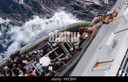 Eine Marine, 11. Marine Expeditionary Unit zugeordnet klettert eine Jakobsleiter aus einem 11-Meter Festrumpf Schlauchboot auf dem Flugdeck der amphibischen Transportschiff Dock USS San Diego (LPD 22) während einer maritimen RAID-Kraft Drill. San Diego, die Makin Island amphibische bereit Gruppe, ist auf ihrer Jungfernfahrt Bereitstellung mit der 11. MEU zur Förderung von Frieden und Freiheit der Meere durch die Bereitstellung von Sicherheit und Stabilität in den USA 7. Flotte Einsatzgebiet. (Foto: U.S. Navy Mass Communication Specialist 2. Klasse Stacy M. Atkins Ricks/freigegeben) Maritime RAID-Kraft Bohrer 140830-N-IK388-036 Stockfoto