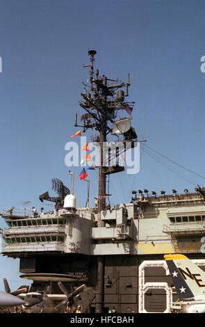 Ein SPS-49 Langstrecken Luft Suche Radar Montage erfolgt vor der Radarmast auf dem Flugzeugträger USS KITTY HAWK (CV-63).  Ein e-2 Hawkeye Airborne Early Warning (AEW) Flugzeug sehen im Vordergrund. Mast der USS Kitty Hawk (CV-63) 1983 Stockfoto