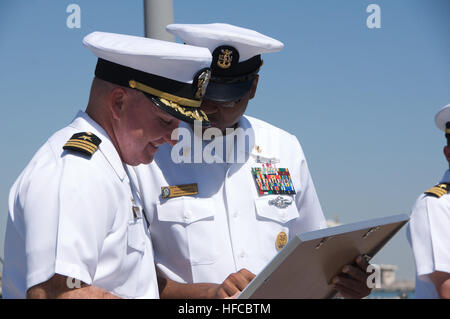 Command Master Chief Jay L. Stuckey präsentiert CMdR Timothy Kott mit dem Schiff Inbetriebnahme Wimpel als er Abschied von der Crew bei einem Befehl Zeremonie auf dem Schiff in Mina Salman Hafen in Manama gebietet. Kott wurde von CMdR Kevin Melody entlastet. (Foto: U.S. Navy Hector Gamez) Melodie entlastet Kott als USS Hopper Commander 262298 Stockfoto