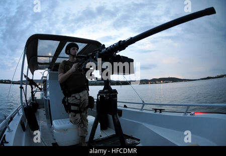 Ein Mitglied des Seeschifffahrtssicherheitsteams der Küstenwache betreibt ein Maschinengewehr des Kalibers .50, während er Guantanamo Bay patrouilliert, um maritimen Antiterrorismus und Gewaltschutz zu bieten. Stockfoto