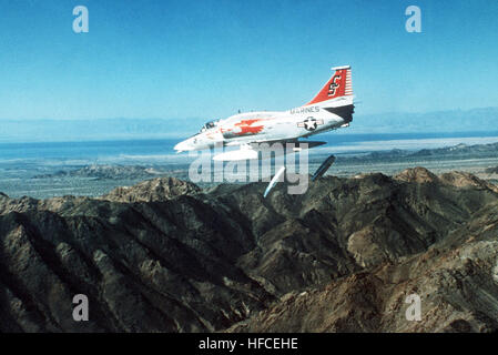 Eine Luft/Luft-linke Seitenansicht eines Marine A - 4M Skyhawk-Flugzeugs fallen zwei Napalm Kanister über den Bergen.  Die A - 4M ist von Marine Attack Training Squadron 102 (VMAT-102). A - 4M VMAT-102 Stockfoto