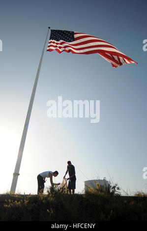 Petty Officer 2. Klasse William Riley und Marine Aviation strukturelle Mechaniker 1. Klasse Joanna Kegler, beide zugewiesenen Joint Task Force Guantanamo Marine Expeditionary Wachbataillon, Abholung Papierkorb neben der US-Flagge auf einem HÃ¼gel, Juni 10. Das clean-Up ist eine der vielen Veranstaltungen, die JTF Guantanamo Petty Officer First Class Association in diesem Sommer in einer Bemühung, mehr Service-Mitglieder raus auf den Trails gehostet wird. JTF Guantanamo führt sicher, humane, rechtliche und transparente Pflege und Obhut der Gefangenen, einschließlich der Militärkommission und die verurteilten bestellt von einem Gericht freigegeben. Th Stockfoto