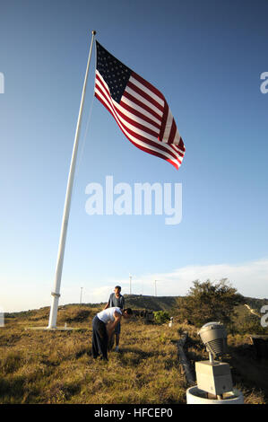 Petty Officer 2. Klasse William Riley und Navy Petty Officer 1st Class Joanna Kegler, beide, die Joint Task Force Guantanamo Marine Expeditionary Wachbataillon, zugewiesen abholen Müll neben die US-Flagge auf einem HÃ¼gel, Juni 10. Das clean-Up ist eine der vielen Veranstaltungen, die JTF Guantanamo Petty Officer First Class Association in diesem Sommer in einer Bemühung, mehr Service-Mitglieder raus auf den Trails gehostet wird. JTF Guantanamo führt sicher, humane, rechtliche und transparente Pflege und Obhut der Gefangenen, einschließlich der Militärkommission und die verurteilten bestellt von einem Gericht freigegeben. Führt das JTF Stockfoto