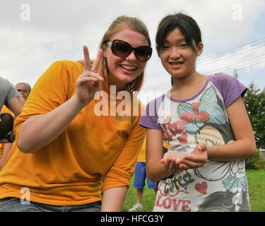 SHICHINOHE, Japan (18. August 2012) Information Systems Technician 3. Klasse Krystal Harlow, Naval Computer und Telecommunciations Station Fernost Ablösung Misawa und Granite Falls, Washington stammende zugewiesen, posiert mit einem Kind für ein Foto an die Biko-de Kinder Care Center in Shichinohe, Japan, 18. August 2012. Segler aus Naval Air Facility Misawa, einschließlich Mieter und bereitgestellten Befehle vorgesehen einen Tag voller Spaß für die Kinder im Heim. (Foto: U.S. Navy Mass Communication Specialist 2. Kenneth G. Takada/freigegeben) Marine Misawa Segler bieten Tag voller Spaß in Japan Waisenhaus 120818-N-VZ Stockfoto