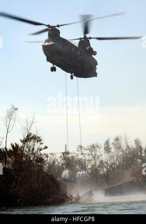 050907-N-5319A-023 New Orleans (7. September 2005) – ein Army National Guard CH-47 Chinook-Hubschrauber Tropfen 15.000 Pfund Säcke mit Sand in einen Damm, die wich, Überschwemmungen die Straßen und Häuser nach Hurrikan Katrina New Orleans geschändet achtzig Prozent der Stadt mit Wasser zu füllen. Der Army National Guard zusammen mit Marine, Armee, Marine, Luftwaffe und Küstenwache wurden mobilisiert, um gemeinsame Task Force Katrina, eine humanitäre Hilfe-Operation in einer gemeinsamen Anstrengung führte durch die Federal Emergency Management Agency (FEMA), in Verbindung mit dem Department of Defense teilzunehmen. US Navy Foto Stockfoto