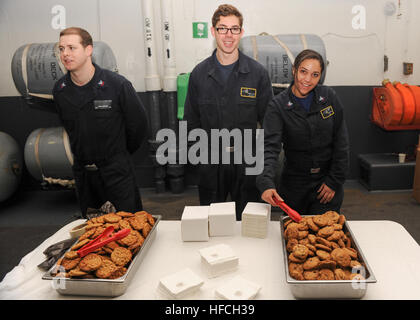 Pazifischer Ozean (14. Dezember 2016) - Segler dienen Cookies während einer Weihnachtsfeier im Hangar des Flugzeugträgers USS Nimitz (CVN-68) Bucht. Nimitz führt Routineoperationen in Vorbereitung auf eine bevorstehende 2017 Bereitstellung im Gange. (US Navy Foto von Seemann Leon Wong/freigegeben) Nimitz Segler dienen Cookies 161214-N-XL056-016 Stockfoto