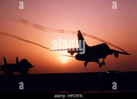 Ein A-7E Corsair II-Flugzeug landet auf dem Flugdeck der nuklear angetriebene Flugzeugträger USS CARL VINSON (CVN-70) bei Sonnenuntergang. A-7E Corsair II Sonnenuntergang Stockfoto