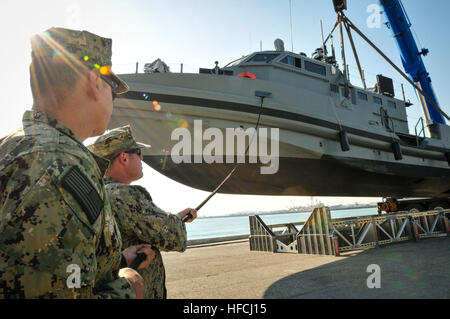 Elektroniker /-in NAVAL SUPPORT Aktivität BAHRAIN (10. Februar 2014) 2. Klasse Andrew Garcia, links, und Bootsmann Mate 2. Klasse Chris Stout, eine Linie zu behandeln, während die Küsten Befehl Boot (CCB) vom Pier und ins Wasser gehoben wird.  Die CCB kam in seinem Heimathafen von Bahrain 8. Februar.  Die CCB ermöglicht eine größere Fähigkeit, dominieren die Litorale und das blaue Wasser durch die Bereitstellung der 5. Flottenchef mehr Optionen zur Erreichung dieser Ziele zu stärken.  (Foto: U.S. Navy Mass Communication Specialist 1. Klasse Felicito Rustique/freigegeben) NSA Bahrain 140210-N-IZ292-107 Stockfoto