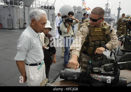 Staff Sgt Max Veliz, ein Marine aus Flotte Anti-Terrorism Security Team Unternehmen Pacific, 3rd Platoon, erläutert Ausrüstung mit einem lokalen Bürger während eines offenen Schiff Tour Events an Bord der U.S. 7. Flotte Flaggschiff USS Blue Ridge (LCC-19) in Tokio Funktionsweise. Blue Ridge Besuch in Tokio ist ein nach außen Demonstration des US-Engagements zur Verteidigung Japans, die starke Beziehung zwischen der U.S. Navy und Japan Maritime Self-Defense Force, und hilft, Frieden und Stabilität in der gesamten Region Ostasien zu erhalten. (Foto von Massenkommunikation Spezialist Seemann Cody Babin) Offenen Schiff-Tour-Event in Stockfoto