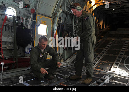 151211-N-ZB122-010 ANDERSEN AIR FORCE BASE, Guam (Dec.  11, 2015) - US Air Force Staff Sgt Renford Forbes (rechts) und Royal Australian Air Force Warrant Officer Rod Cairns (links) hilft bei der Reinigung des Flugzeugs während Betrieb Weihnachten fallen, 11. Dezember 2015. Betrieb Weihnachten Drop ist das Department of Defense der längsten laufen humanitäre Luftbrücke Mission wo drop c-130 Mannschaften kostengünstige niedriger Höhe Bundles, die zu 56 Inseln innerhalb des Commonwealth der nördlichen Marianen, Föderierte Staaten von Mikronesien und Republik Palau versorgen. Dieses Jahr markiert die erste jemals Tril Stockfoto