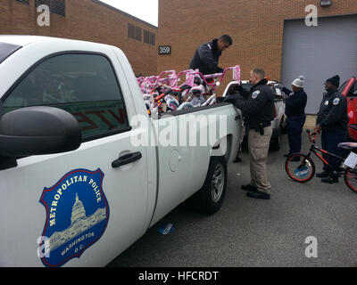 Polizeibeamte des Metropolitan Police Department laden Fahrräder, die dem Toys for Tots-Programm der U.S. Marine Corps Foundation gespendet wurden, in Fahrzeuge auf der Joint Base Anacostia-Bolling (JBAB) zur Verteilung an unterprivilegierte Kinder in Washington, D.C. mit Unterstützung von Militärpersonal, Zivilpersonal und Freiwilligen. Stockfoto
