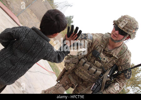 US Army Spc. Joseph Sullivan, Recht, Sicherheit Kraft Mitglied des Teams für Provincial Reconstruction Team (PRT) Farah, bekommt ein "high Five" von einem lokalen afghanischen jungen während eines Gefechts Schlüssel Führer bei Farah Stadtgefängnis, Dez. 6.  PRT Farah widmet sich trainieren, beraten und unterstützen afghanische Staats-und Regierungschefs bei den Stadtwerken, Kreis und Landesebene in Farah Provinz, Afghanistan.  Ihre zivile Militär-Team besteht aus Mitgliedern der US-Marine, US Army, US Department of State und der Agentur für internationale Entwicklung (USAID).  (U.S. Navy Photo von HMC Josh Ives/freigegeben) PRT Farah con Stockfoto