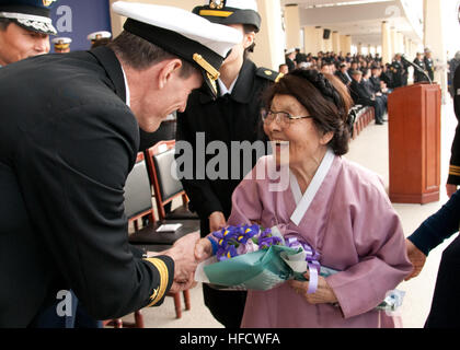 JINHAE, Republic of Korea (22. Februar 2013) Rear Admiral Bill McQuilkin, Kommandeur der US Naval Forces Korea, stellt Hong Eun-Hye, "Mutter der koreanischen Marine", Witwe von Korea das erste Chef der Marineoperationen Sohn Won-il, mit einem Blumenstrauß in der Republik von Korea (ROK) Marine-Akademie-Klasse von 2013 Graduierung. McQuilkin gehörte zu viele US-Militärs anwesend, die ihre Unterstützung für die neu in Betrieb genommenen ROK Marineoffiziere zeigte. (Foto: U.S. Navy Mass Communication Specialist 2. Klasse Joshua B. Bruns/freigegeben) 130222-N-TB410-250 beitreten das Gespräch http://www.facebook.co Stockfoto