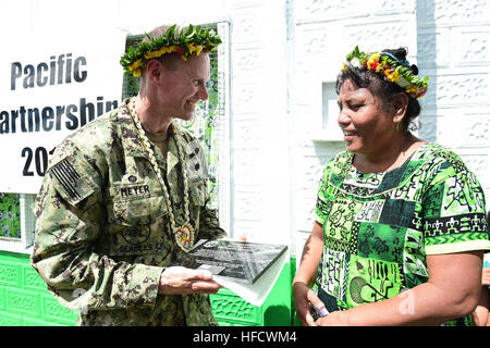 TARAWA, Kiribati (17. Juni 2015) – Commodore, Task Force Forager Captain James Meyer präsentiert eine Gedenktafel an dem Auftraggeber der Red Beach Primary School, Mary Noere, während eine Banddurchtrennungszeremonie 17 Juni. Das Band Schneiden markiert den Abschluss der Renovierungen von Seabees Pazifischen Partnerschaft 2015 befestigt. Task Force Forager ist an Bord des Military Sealift Command-gemeinsame high-Speed-Schiffes USNS Millinocket (JHSV 3) begonnen. Millinocket dient als sekundäre Plattform für Pacific Partnership, unter der Leitung von expeditionary Befehl Element 30. Naval Construction der Marine Regiment (30 NCR) von Stockfoto