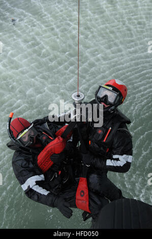 130228-N-LY640-057 (28. Februar 2013) NORFOLK Naval Aircrewman (Hubschrauber) 1. Klasse Christian Lyons und Marine Aircrewman (Hubschrauber) 3. Klasse Christopher Shapiro, zugewiesen, Hubschrauber Meer bekämpfen Squadron (HSC) 9, sind an Bord ein MH-60 s Sea Hawk-Hubschrauber bei Suche und Rettung Training gehisst.  (Foto: U.S. Navy Mass Communication Specialist 2. Klasse Sandi Grimnes/freigegeben) Segler sind an Bord ein MH-60 s Sea Hawk-Hubschrauber im Such- und Rettungsdienst Ausbildung 130228-N-LY640-057 gehisst. Stockfoto