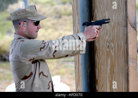 GUANTANAMO BAY auf Kuba – Navy Waffenwart 1. Klasse Michael Mrugalski, eine Wache mit Joint Task Force Guantanamo Marine Expeditionary Guard Battalion, Brände, die ein Rollout-Service Pistole während eines Waffen-Qualifikation am Luv Pistole Bereich, 19. Juli 2010. Die NEGB bietet einen Anteil JTF Guantanamo Wache Kraft. JTF Guantanamo bietet sichere, humane, legale, transparente Pflege und Obhut der Gefangenen, einschließlich der Militärkommission und die verurteilten freigegeben von einem Gericht angeordnete. Die JTF führt Intelligenzansammlung, Analyse und Verbreitung für den Schutz von Gefangenen und personn Stockfoto