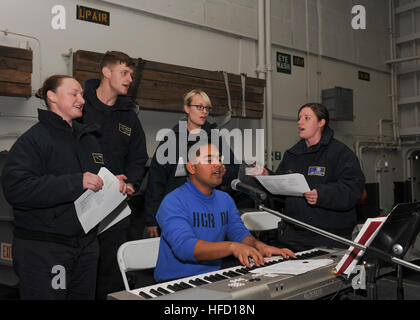 Pazifischer Ozean (14. Dezember 2016) - Segler zusammen singen während einer Weihnachtsfeier im Hangar Bucht der Flugzeugträger USS Nimitz (CVN-68). Nimitz führt Routineoperationen in Vorbereitung auf eine bevorstehende 2017 Bereitstellung im Gange. (US Navy Foto von Seemann Leon Wong/freigegeben) Matrosen singen 161214-N-XL056-004 Stockfoto