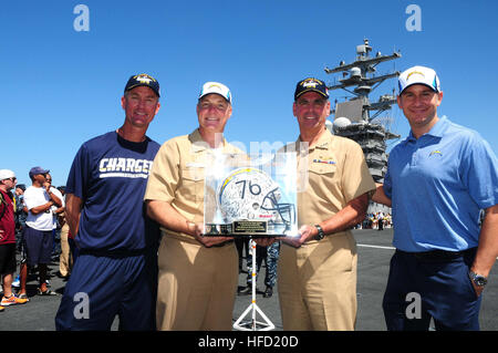 Posieren Sie Vice Admiral David H. Buss, Commander Naval Air Forces und Captain Christopher Bolt, Kommandant des Flugzeugträgers USS Ronald Reagan (CVN-76), mit Mike McCoy (links), San Diego Chargers Cheftrainer und Alex Spanos (rechts), Besitzer der San Diego Chargers, während eine Moral, die Förderung der Veranstaltung an Bord des Schiffes. Ronald Reagan ist derzeit vertäut und Zuhause im Naval Base Coronado portiert. (Foto: U.S. Navy Chief Masse Kommunikation Spezialist Terry Feeney/freigegeben) San Diego Chargers besuchen USS Ronald Reagan (CVN-76) 130828-N-QM098-059 Stockfoto