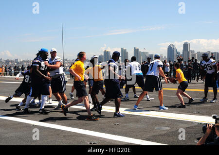 Segler und Profi-Fußballer aus der San Diego Chargers-Praxis auf dem Flugdeck des Flugzeugträgers USS Ronald Reagan (CVN-76). Ronald Reagan ist derzeit vertäut und Zuhause im Naval Base Coronado portiert. (Foto: U.S. Navy Chief Masse Kommunikation Spezialist Terry Feeney/freigegeben) San Diego Chargers besuchen USS Ronald Reagan (CVN-76) 130828-N-QM098-076 Stockfoto