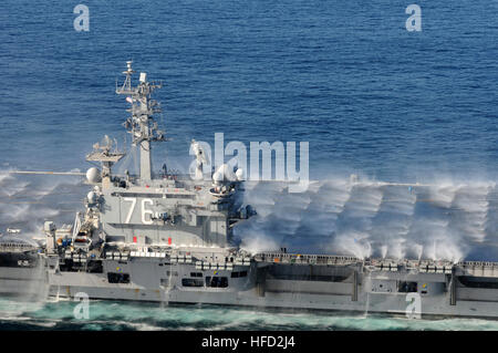 Als der Nimitz-Klasse-Flugzeugträger USS Ronald Reagan durch den Pazifischen Ozean am Ende eines Fly-off für das örtlich festgelegtflügel Flugzeug des Carrier Air Wing 14-Transite sind Gegenmaßnahme Wash-down Sprinkler aktiviert. Die Gegenmaßnahme Wash-down Sprinkler dienten als Spülmittel nach einem Flight Deck schrubben Übung, aber kann auch verwendet werden, im Falle einer chemischen, biologischen oder Strahlung angreifen, um giftige Stoffe aus dem Schiff zu waschen. Ronald Reagan ist auf einer Routine-Bereitstellung, derzeit in der 3. Flotte Verantwortungsbereich. Peeling-Übung schließt USS Ronald Reagan Air Fly-off Stockfoto