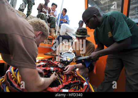 Marine Taucher Petty Officer 2. Klasse Jeremy Weber und Marine Taucher Petty Officer 1st Class Matt Schlabach, zugeordnet der vorwärts-bereitgestellt, Mobile Tauch- und Salvage Unit 2 und Uganda Völker Defense Force CPL. Joel Amanya überprüfen Sie Pre-mission KM 37 Tiefsee Tauchen Helm. MDSU-2 ist Teil einer Suche und Bergung Operation für ein Flugzeug Ilyushin 76 kombiniert Joint Task Force-Horn von Afrika und der Regierung von Uganda durchgeführt werden. Suche und Bergung Betrieb in Uganda 161752 Stockfoto