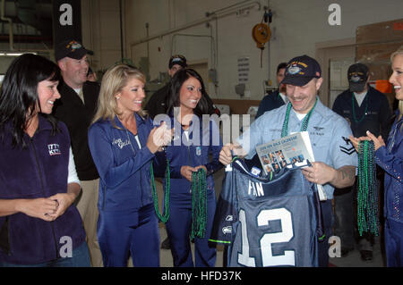 Petty Officer 2. Klasse Mario Caracciolo ist mit einem Seattle Seahawks-Fan-Trikot und Sachpreise in Everett, Washington, drei von den Seahawks Cheerleadern vorgestellt. Caracciolo erhielt auch Tickets für die Seahawks Monday Night Football Spiel für Military Appreciation Day. Seattle Seahawks 65680 Stockfoto