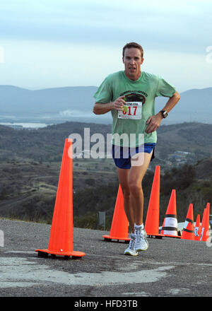 GUANTANAMO BAY auf Kuba – Navy Lt. Eamon O'Reilly überquert die Ziellinie auf John Paul Jones Hügel während der American Red Cross 5K Run/Walk, 21. März 2010. Mehr als 250 Menschen aus Joint Task Force Guantanamo und Nabel Station Guantanamo Bay kamen zusammen um das amerikanische Rote Kreuz 5 K laufen/gehen zu unterstützen. JTF Guantanamo führt sicher, humane, rechtliche und transparente Pflege und Obhut der Gefangenen, einschließlich der Militärkommission und die verurteilten bestellt von einem Gericht freigegeben. Die JTF führt Intelligenzansammlung, Analyse und Verbreitung für den Schutz von Insassen und Personal wo Stockfoto