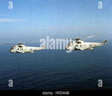 Eine Luft/Luft-linke Seitenansicht der zwei Hubschrauber Anti-Submarine Squadron 14 (HS-14) SH - 3 H Sea King Hubschrauber unterwegs auf dem Flugzeugträger USS RANGER (CV-61) als die Köpfe Schiff außerhalb des Hafens seine WestPac 90 beginnen Kreuzfahrt. SH - 3H Sea Kings HS-14 im Flug 1990 Stockfoto