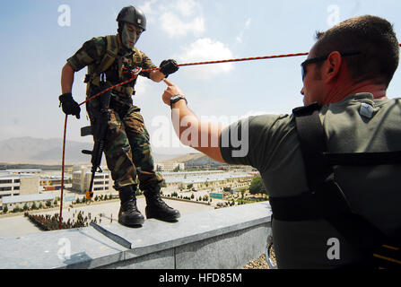 KABUL, Afghanistan (9. August 2010) French Army Staff Sgt Virion, Recht, EPIDOT Programm Afghan National Army (ANA) Berater, signalisiert afghanischen Kapitän Abdulhai, Abseilen Demonstration im Rahmen einer Pre-Ramazan Zeremonie in Kabul Military Training Center (Ausbildungszentrum) beginnen. ANA und Besuch Koalition Führer sah Sicherheit und schnelle Response-Teams ihre Reaktionen auf simulierte Angriffe Aufständischer zu demonstrieren. Vier ANA Ausbilder im Ausbildungszentrum simuliert einen Gegenangriff durch Brennen Rohlinge aus dem Dach eines mehrstöckigen Gebäudes, dann Abseilen der Seite zur Unterstützung bei der Abwehr der "Angreifer". (US Navy Pho Stockfoto