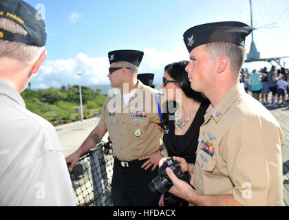 PEARL HARBOR, Hawaii (9. April 2013) von rechts, Aviation Boatswain Mate (Handler) 1. Klasse (AW/SW) Shawn-Patrick Bland, Commander, Oberfläche Seestreitkräfte, Pazifikflotte; seine Frau Melanie Bland und Builder 1. Klasse (SCW/EXW) Alfred Fehling, von Marine Expeditionary Combat Command Pacific hören einen Vortrag über die Brand-Genauigkeit und der Schaden von einer der runden erstellt bei einem Rundgang durch das Schlachtschiff Missouri Memorial aus das Schiff Waffen abgefeuert. Meer und Küste Soja nominierten nehmen diese Woche in einer Vielzahl von persönlichen und beruflichen Auswertungen sowie Führung, n Stockfoto