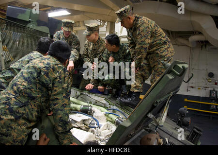 US-Marines zugewiesen, speziellen Zweck Marine Air-Ground Task Force Süd und peruanischen Marines inspizieren den Motor eines U.S. Marine Corps leichten gepanzerten Fahrzeugs bei einem Rundgang durch die amphibischen Angriff Schiff USS America (LHA-6) in Callao, Peru, 1. September 2014. Die neu in Betrieb genommenen amphibischer Angriff Schiff USS America (LHA 6) begab sich auf eine Mission Ausbildung Engagements mit Partnerstaaten auf dem amerikanischen Kontinent durchzuführen, bevor Sie zu ihrer neuen Heimat Hafen von San Diego melden. Die America wurde eingerichtet, um 11. Oktober 2014 feierlich in Betrieb genommen werden. (Foto: U.S. Navy Mass Communication Specialist 1. Cl Stockfoto