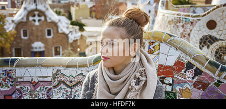 Barcelona-Handschrift. elegante Frau im Mantel in Barcelona, Spanien, Blick in die Ferne auf Bank sitzend Stockfoto