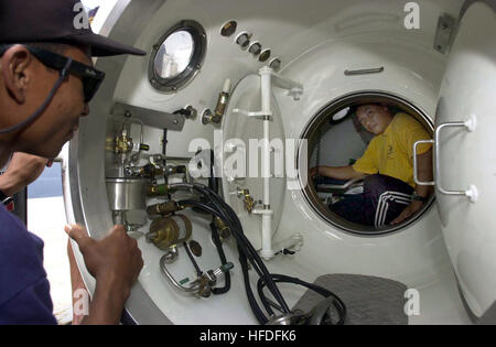 010719-N-9271Z-003 Lumut, Malaysia (19. Juli 2001)--Lt. CMdR Wanzaldi Abdul, von der Royal Malaysian Navy sieht wie eine Transportable Recompression Chamber System (TRCS) auf Lt. CMdR Zaini Awangnik inspiziert.  Diving Bergung Mobilteil - führt eine (MDSU-ONE) Training mit Royal Malaysian Navy Taucher während der siebten jährlichen flott Bereitschaft Zusammenarbeit und Ausbildung (CARAT) 2001 Übung.  Jeden Sommer findet in der gesamten westlichen Pazifik Karat, eine Reihe von bilateralen Übungen statt.  Ziel ist es, regionale Zusammenarbeit stärken und fördern die Interoperabilität mit jedem teilnehmenden Ländern Stockfoto