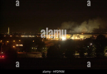 Rauch und Flammen steigen aus dem Pentagon auf, nachdem ein entführtes Verkehrsflugzeug am 11. September 2001 in das Gebäude abgestürzt war, während Notfallhelfer Feuer bekämpfen und nach Überlebenden suchen. Stockfoto