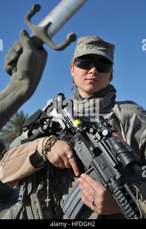 Senior Airman Sheana Davis von Fort Knox, Kentucky, ein US-Air Force Flieger, 11. Sicherheit Kräfte Squadron, Abteilung 3, 732 Expeditionary Sicherheit Kräfte Squadron, 1st Brigade Combat Team, 4. US-Infanteriedivision Posen für einen Fototermin vor dem gekreuzt Schwerter oder Hände des Sieges zugewiesen. Dieses Denkmal wurde nach dem Iran-Irak-Krieg für Saddam Hussein während seiner Herrschaft als Diktator, befindet sich in Bagdad, Irak, vor 18 Jahren 4. Dezember 2008 erstellt. Luftwaffe Sicherheitspatrouille 136714 Stockfoto