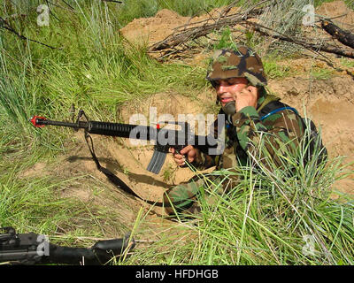 Am 26. Juli 2002 kommuniziert Steelworker 3rd Class während einer Mini-Feldübung in Camp Swift, Austin, Texas, die Strategie aus einem Foxhole. Die U.S. Navy Seabees unterstützen die Front der Navy und des Marine Corps im Bau- und Heckbereich und tragen so zu globalen Baumissionen bei. Stockfoto