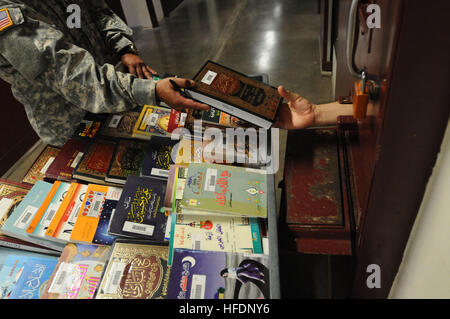 GUANTANAMO BAY auf Kuba – A Soldier aus der Häftling Bibliothek übergibt ein Buch einem Häftlings in fünf Lager 16 Februar.  JTF Guantanamo bietet sichere, humane, legale, transparente Pflege und Obhut der Gefangenen, einschließlich der Militärkommission und die verurteilten freigegeben von einem Gericht angeordnete. Die JTF führt Intelligenzansammlung, Analyse und Verbreitung für den Schutz von Insassen und Personal arbeitet in JTF Guantanamo Einrichtungen und zur Unterstützung des Krieges gegen den Terror. JTF Guantanamo unterstützt Office of Military Commissions, Strafverfolgung und Kriegsverbrechen Untersuchungen Stockfoto