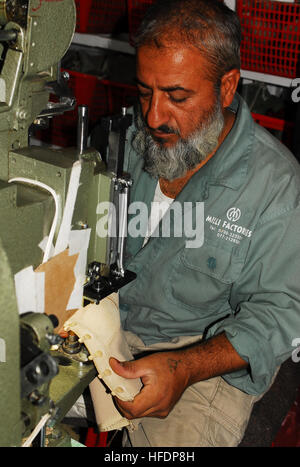 KABUL, Afghanistan (22. Juli 2010) – Kunsthandwerk ein Arbeiter in der Fabrik von Kabul Melli Springerstiefel für afghanische Kräfte. U.S. Navy Rear Admiral Kathleen Dussault, Kommandant der Task Force 2010, präsentierte das Werk mit ein Qualitätszertifikat Qualitätssicherung, mit denen es formal liefern startet im afghanischen nationalen Sicherheitskräfte. Befindet sich in der afghanischen Hauptstadt Kabul, kann das im Besitz der afghanischen Werk etwa 2.400 Stiefel pro Tag produzieren. (Foto: U.S. Navy Chief Masse Kommunikation-Spezialist Brian Brannon / veröffentlicht) Ein Arbeiter in der Fabrik von Kabul Melli Kunsthandwerk Springerstiefel (4919575166) Stockfoto